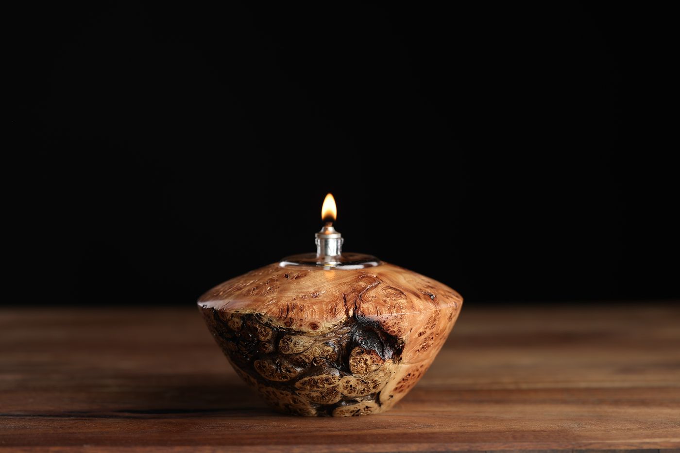Chinle: a blond juniper burl oil lamp with angled shoulders and a dark seam, lit